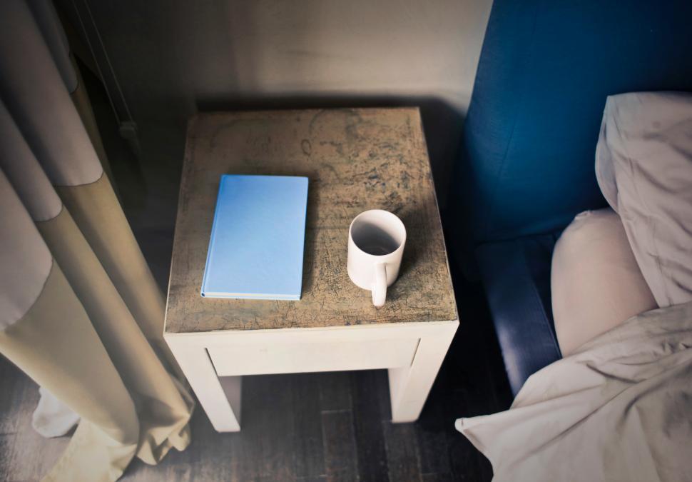 a-diary-and-a-coffee-mug-on-the-bed-side-table.jpg