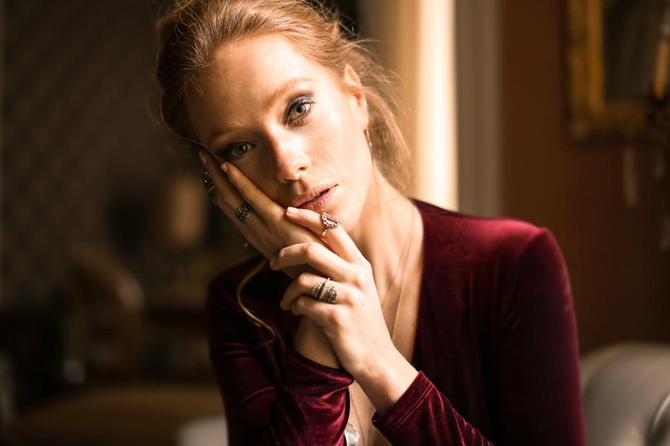 Free Image of A young blonde woman wearing a red velvet dress posing indoors 