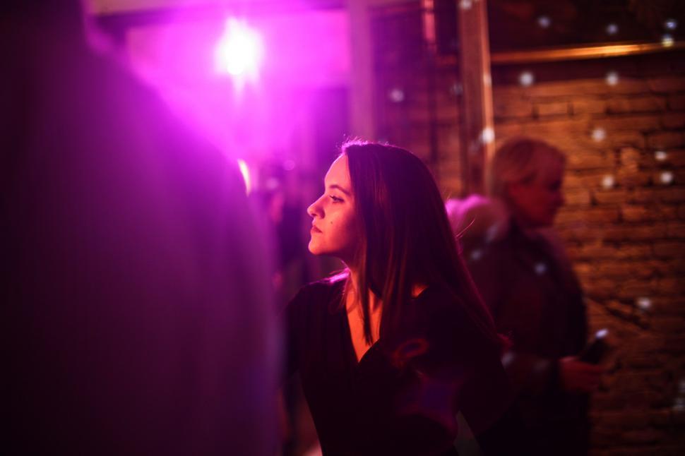 Free Image of A young brunette woman sitting in a bar 