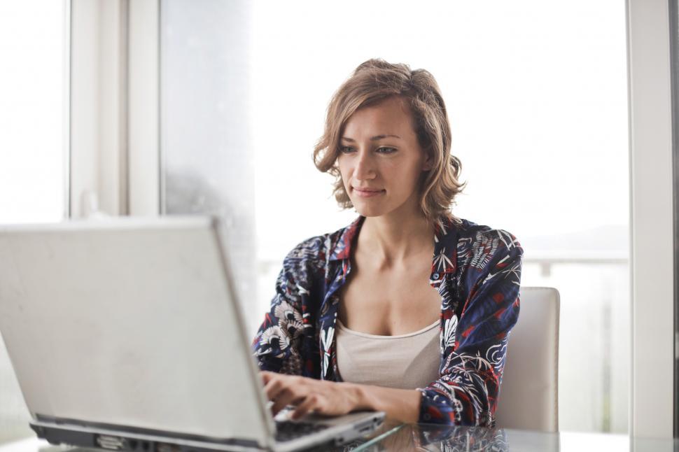 Free Image of A young blonde woman working on her laptop 