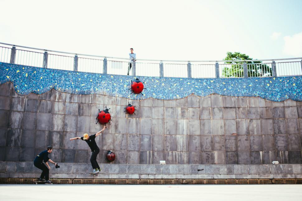Free Image of An onlooker watching one skateboarder photographed by another 