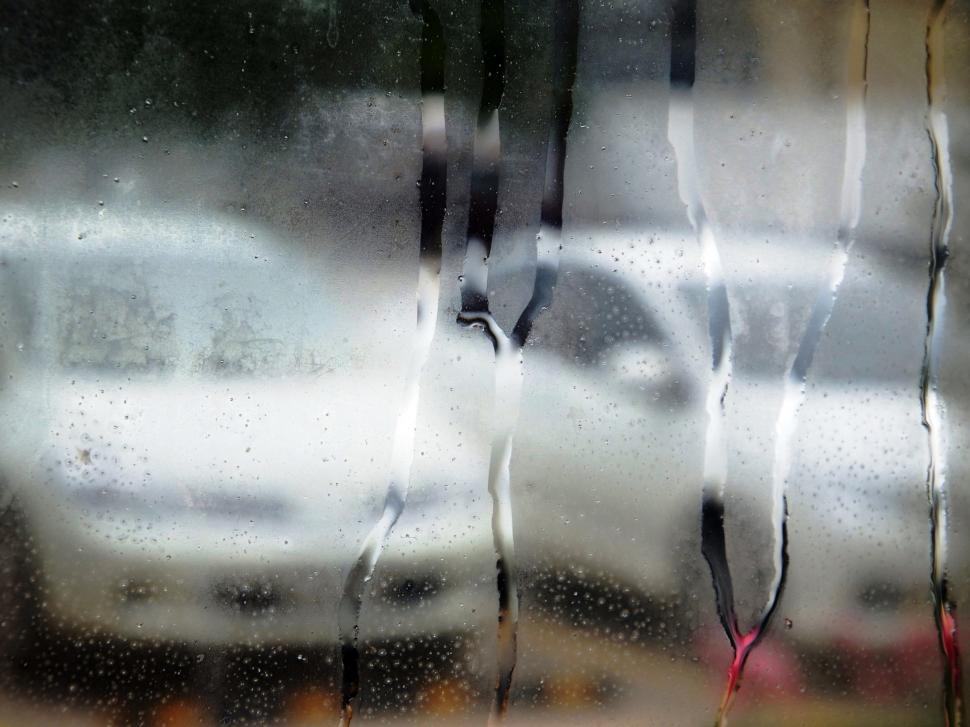 White cars through a steamed up window with water droplets