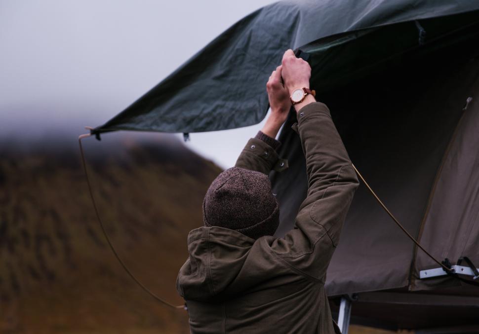 A young caucasian man setting up tent