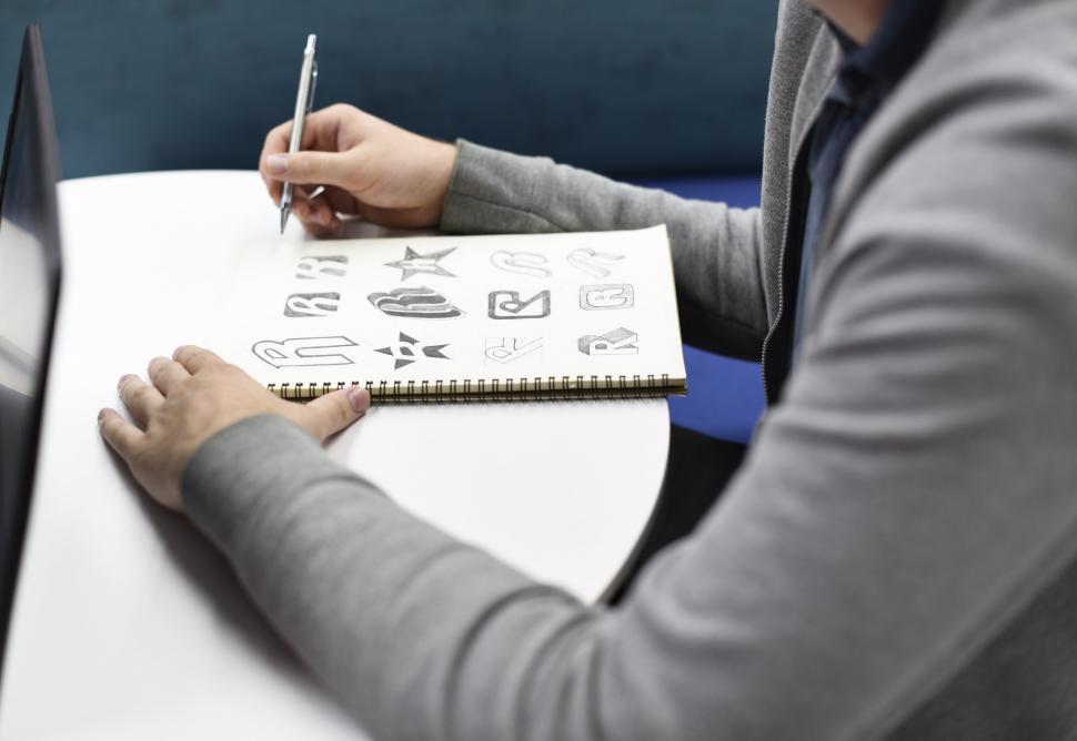 Free Image of An artist s hands creating logos on the sketch book 