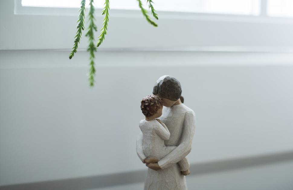 Free Image of A Stone sculpture of a mother holding a baby 