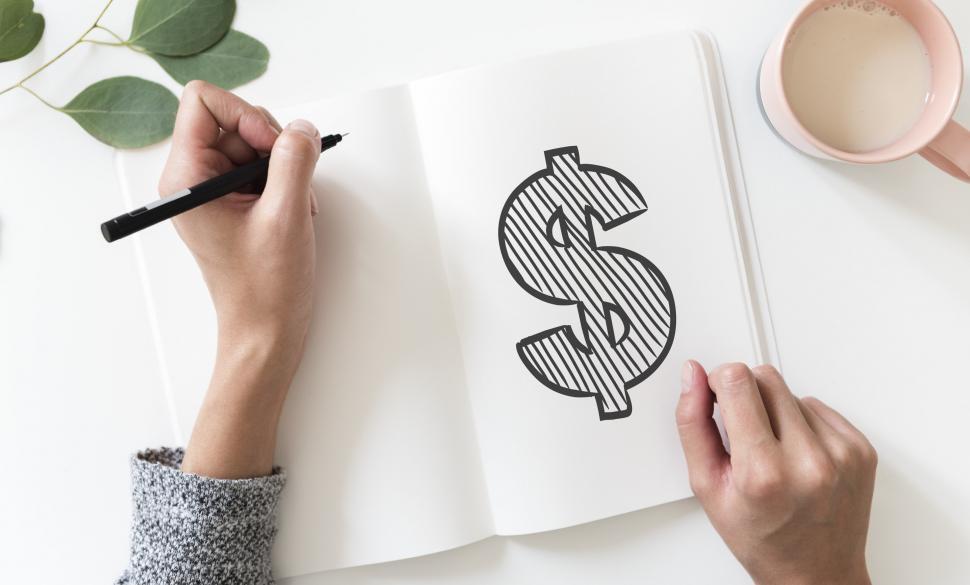 Free Image of Over the head view of a dollar sign drawn on white notebook 