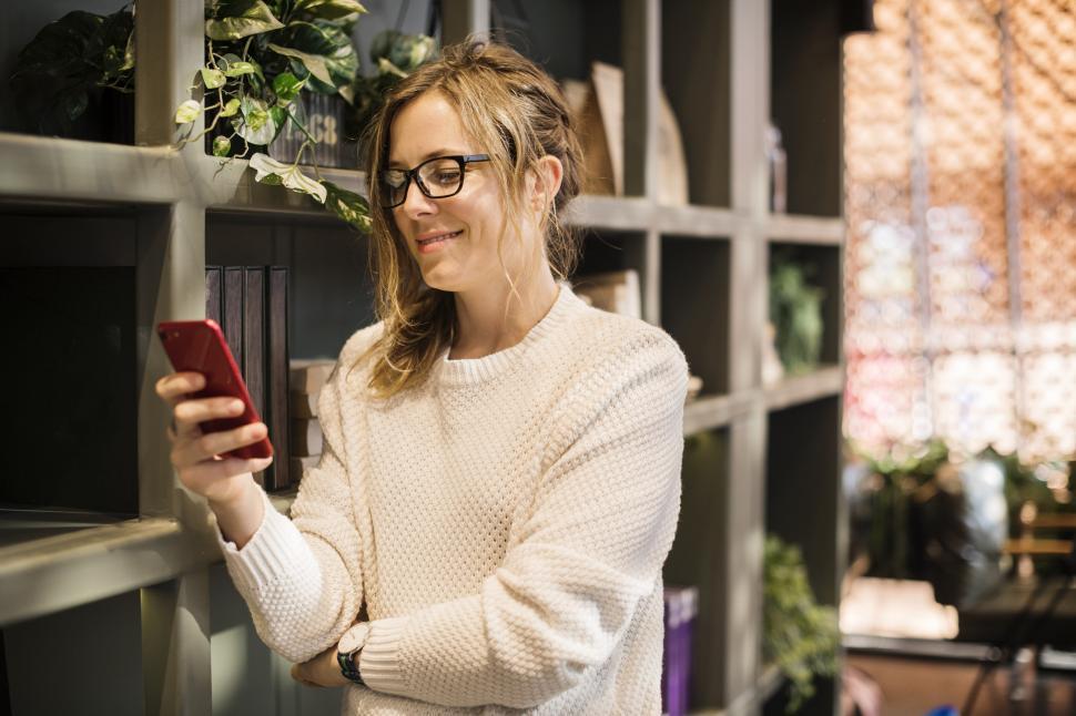 Free Image of Close up of a young Caucasian woman looking at her mobile phone 