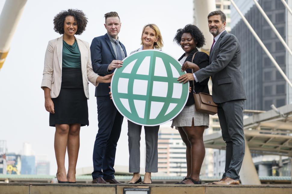 Free Image of Colleagues posing with a globe symbol cardboard cutout 