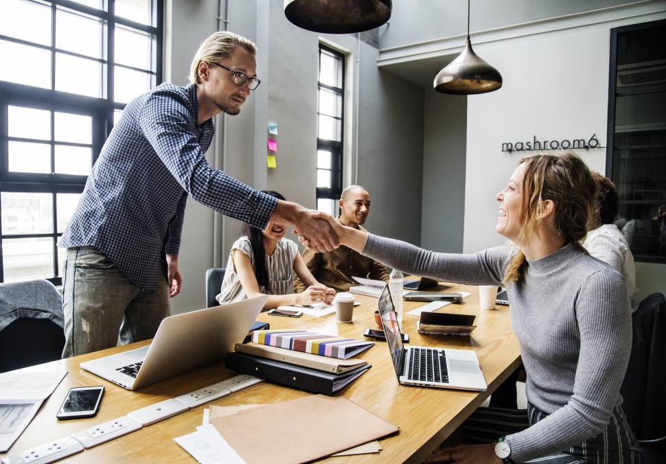 Free Stock Photo of Handshake across table between two business people