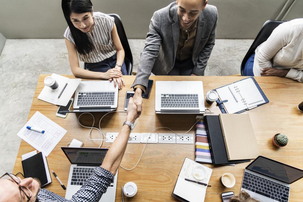 Free Image of Handshake across a crowded table 