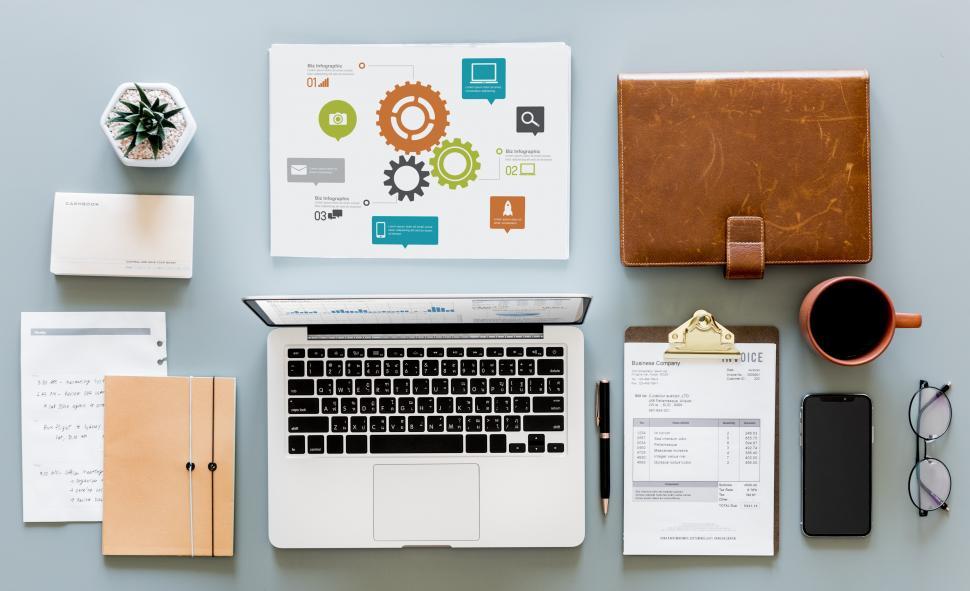 Free Image of Laptop and infographic with other items on the office table 