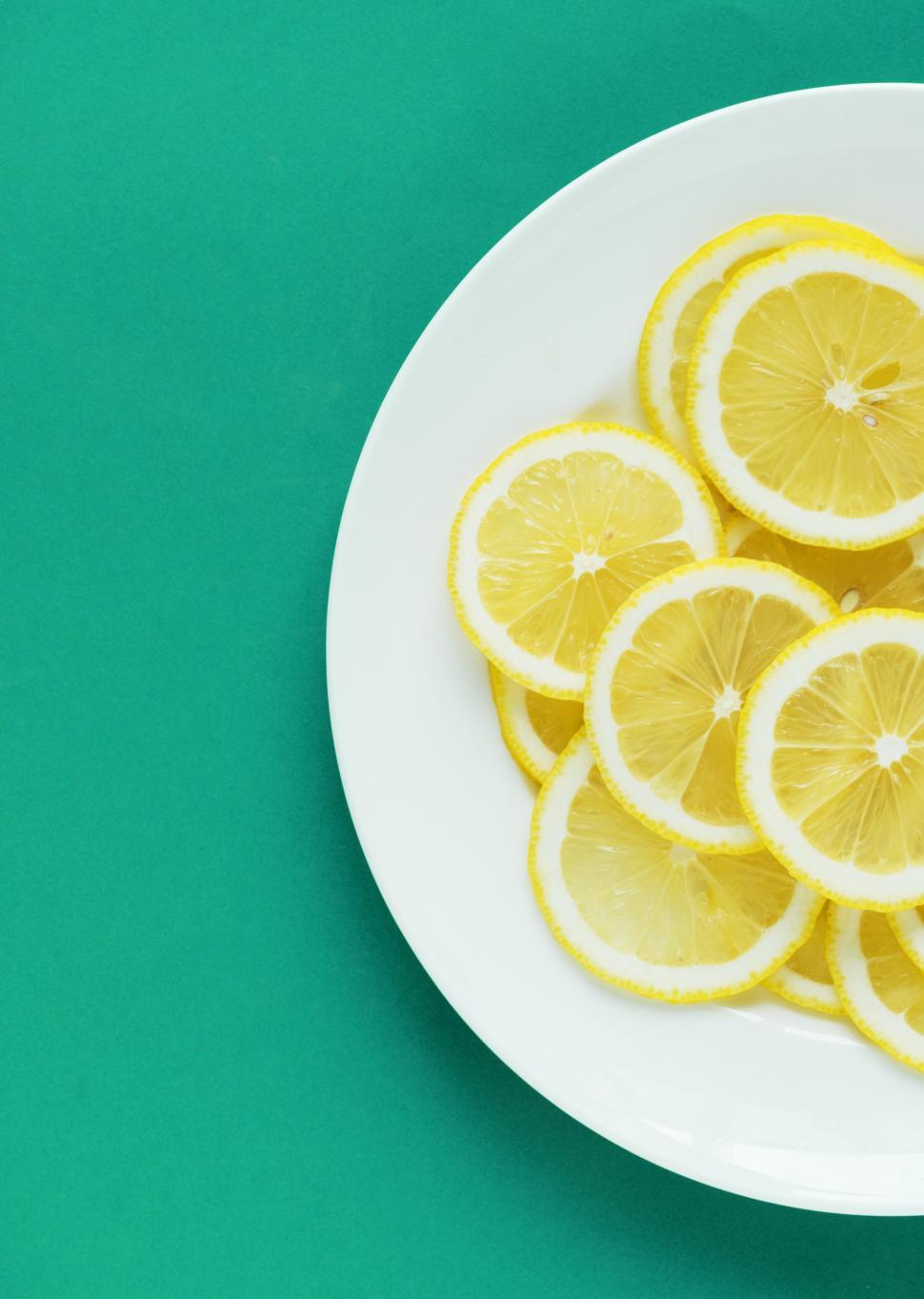 Free Image of Flat lay of lemon slices on white plate, partial view 