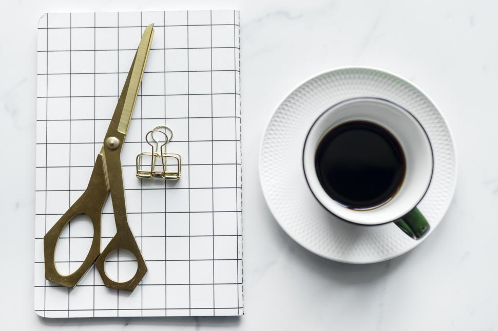 Free Image of Flat lay of a mobile phone alongside a notebook and scissors 