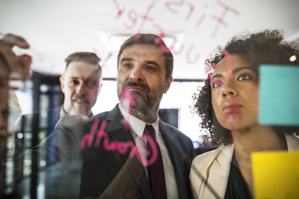Free Image of A bearded businessman drawing a graph on the glass panel 