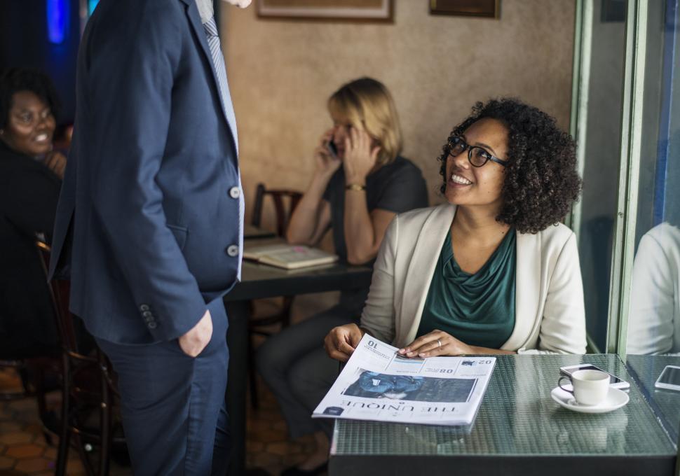 Free Image of A young woman greeting a colleague at a cafe 