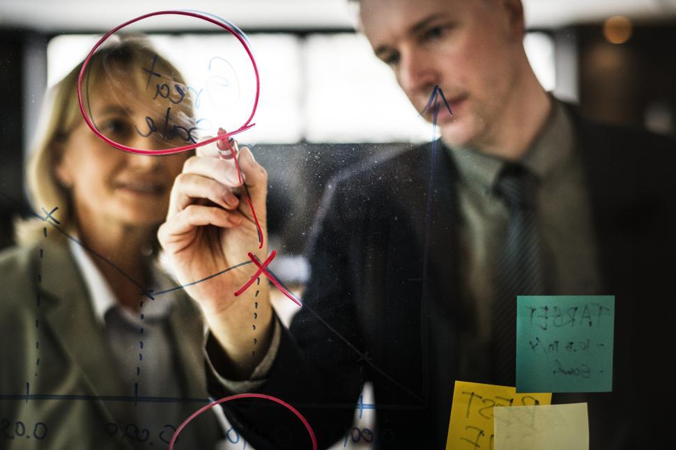 Free Image of A young Caucasian businessman drawing a graph on the glass panel 