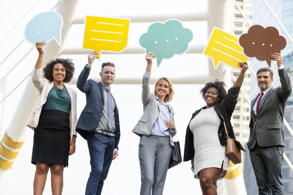 Free Image of A group of colleagues raising shaped speech bubble cutouts 