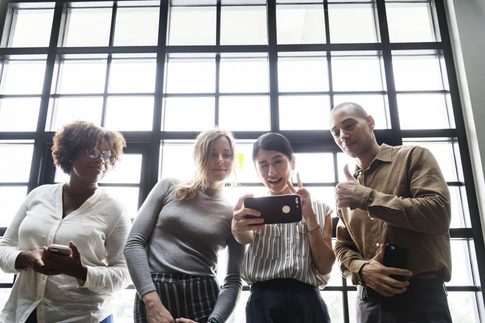 Free Image of Multiethnic colleagues looking at a mobile devices 