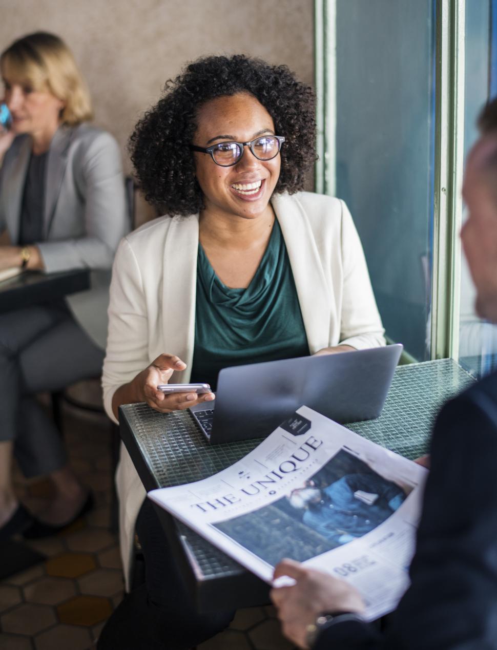 Free Image of A young woman holding her mobile phone during business meal at a cafe 