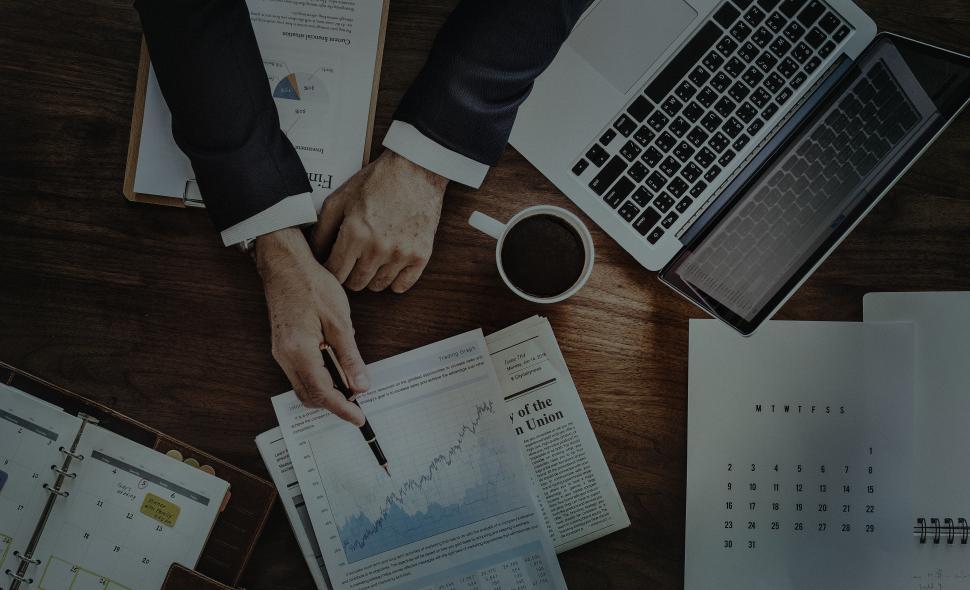 Free Image of Dark overhead view of a businessman pointing at a graph on the table 