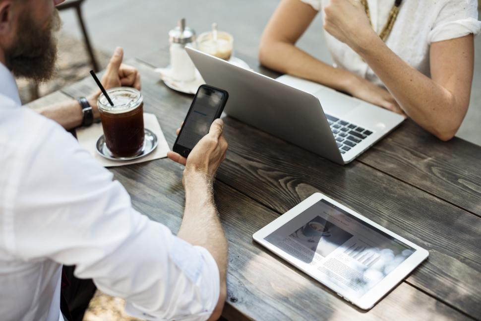 Free Image of Close up of two business people discussing at an outdoor restaurant table 