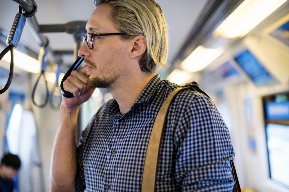 Free Image of A bearded Caucasian man straphanging on the train 