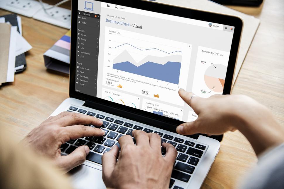 Free Image of Person typing on the laptop, looking at charts 