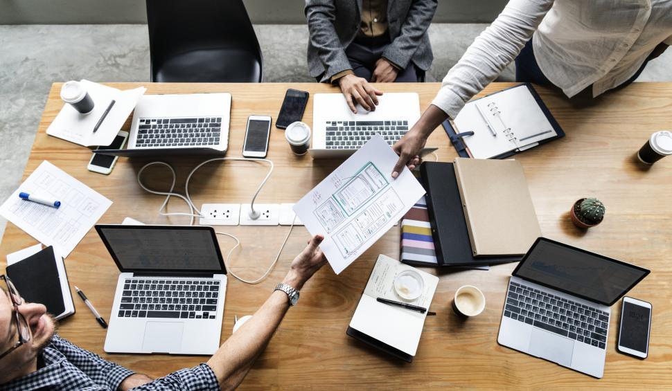 Free Image of Overhead view a design documents being shared between two colleagues 