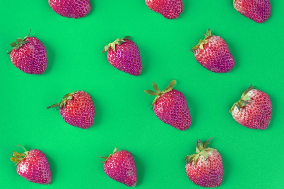 Free Image of Flay lay of strawberries on green surface 
