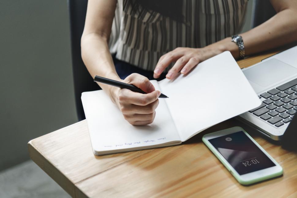 Free Image of Close up of a woman writing in a blank notebook 