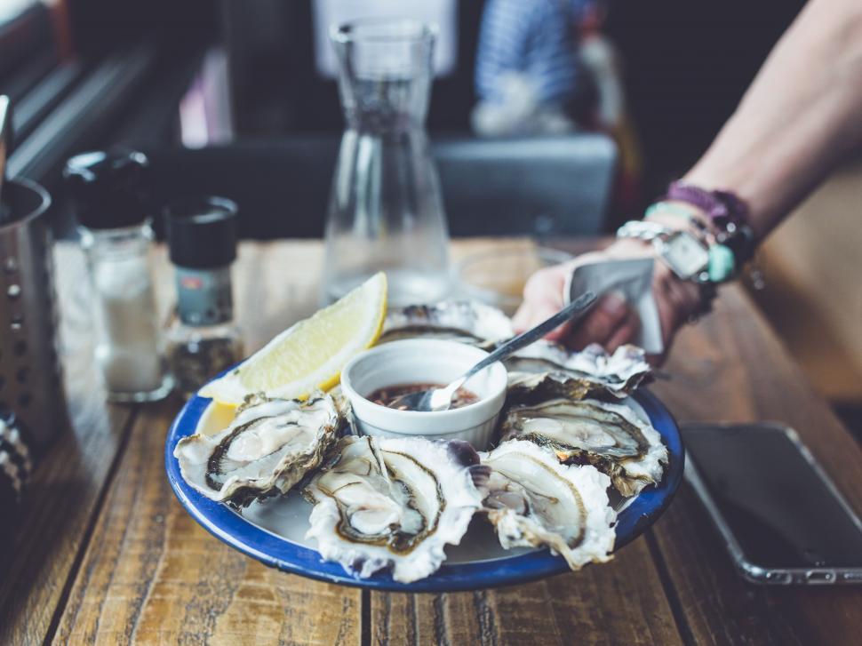 Free Image of Oysters plate with lemon on wooden table  