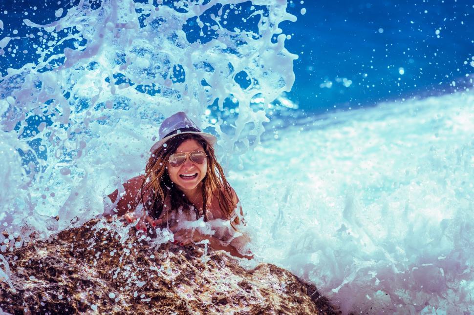 Free Image of Woman In Hat Enjoying Wave Splashes  