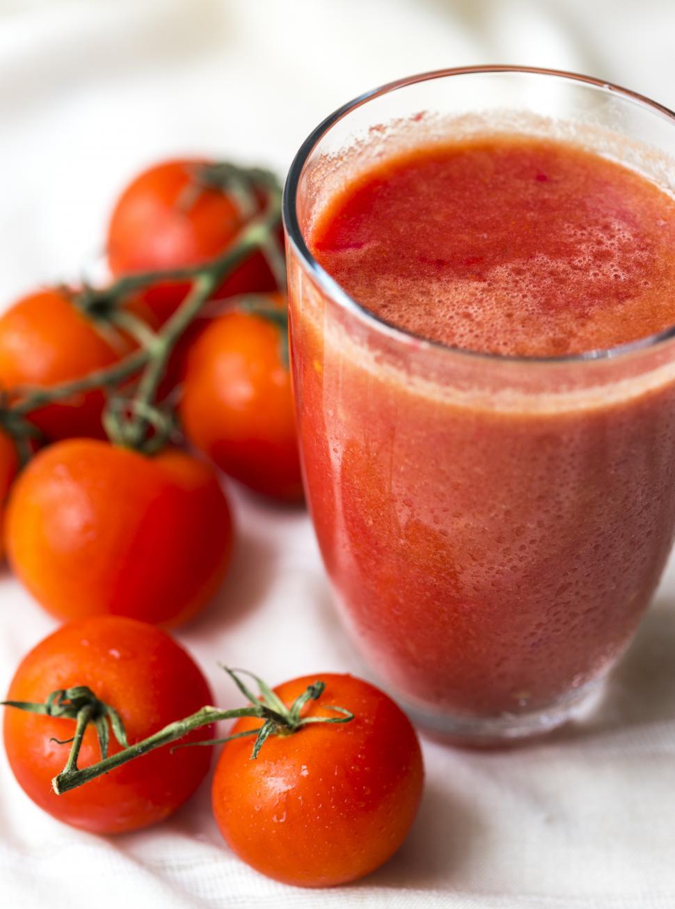 Free Image of Close up of a glass of tomato juice with whole tomatoes 