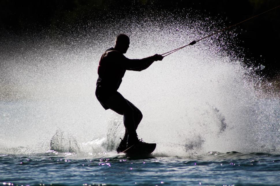 Free Image of Silhouette of Man Surfboarding in ocean waves 