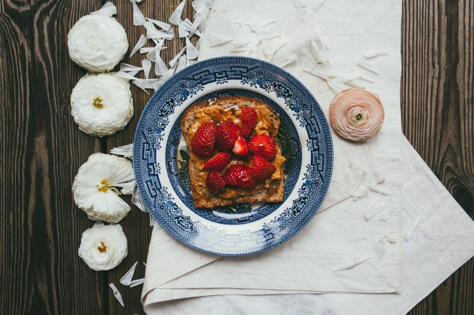 Free Image of Strawberry sandwich and white flowers petals  