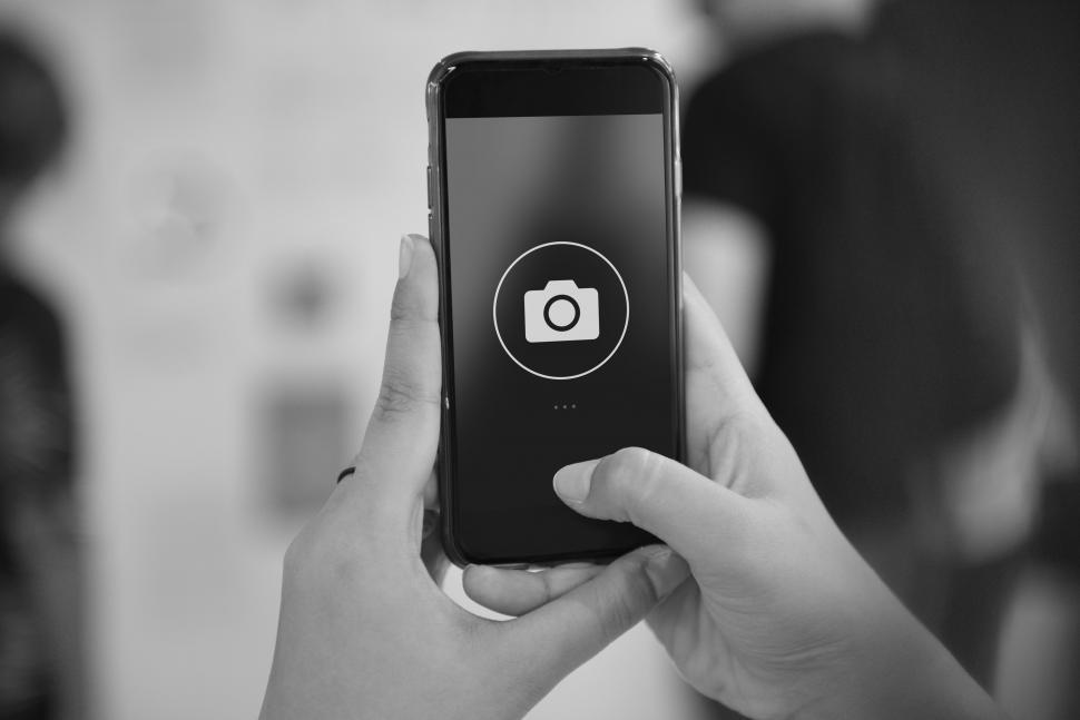 Free Image of Close up of a smart phone in a persons hands with camera icon 
