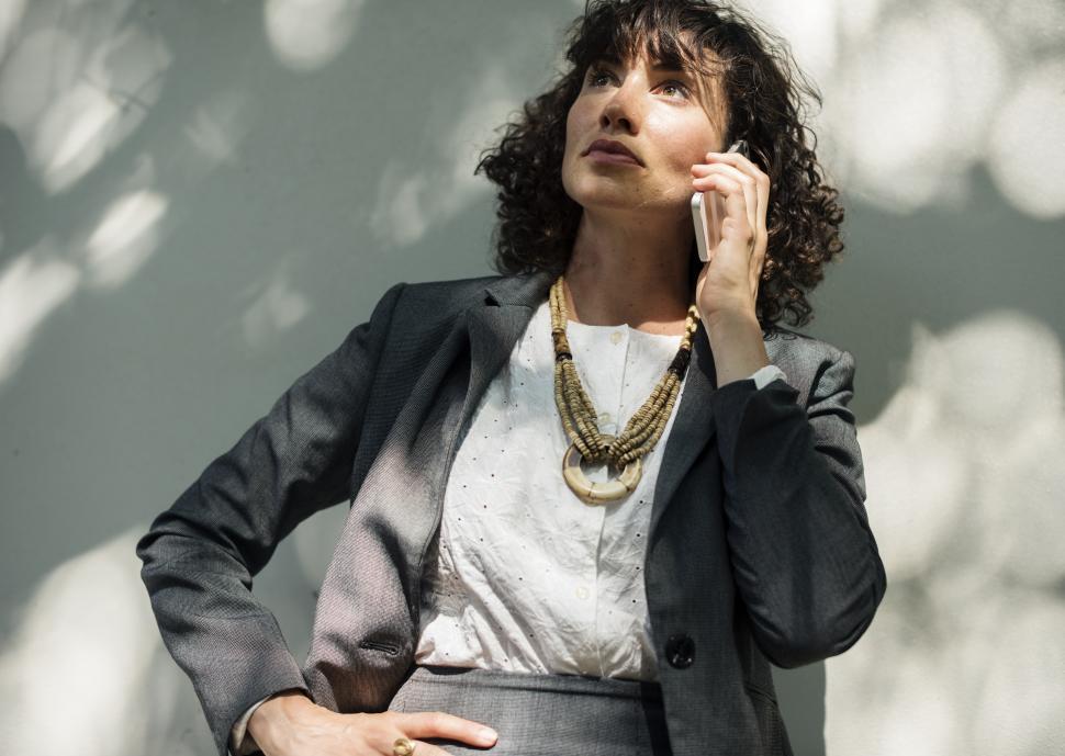 Free Image of A smiling young woman listening to a call on her mobile phone 
