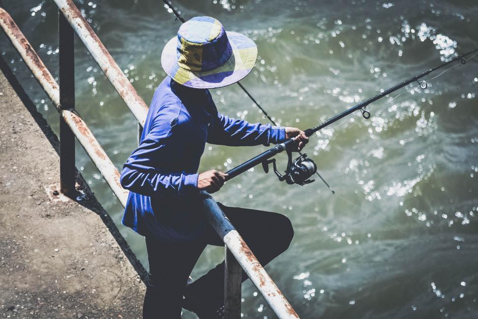 Premium Photo  Man holding a fishing rod standing on a bridge over a river  in the village where he is a regular outdoor fishing on a fun and relaxing  holiday vertical