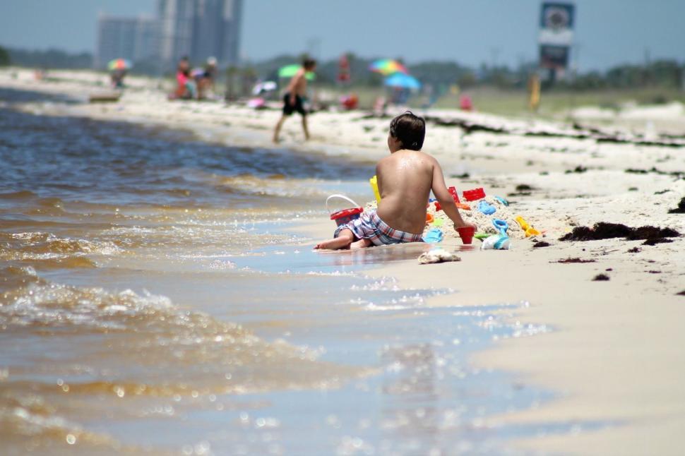 Free Image of Young Boy Playing With Beach Sand  