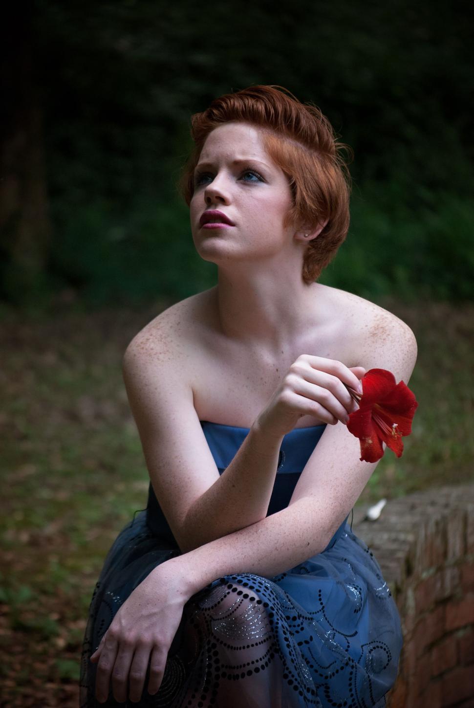 Free Image of Woman Holding Red Flower - Looking Up  