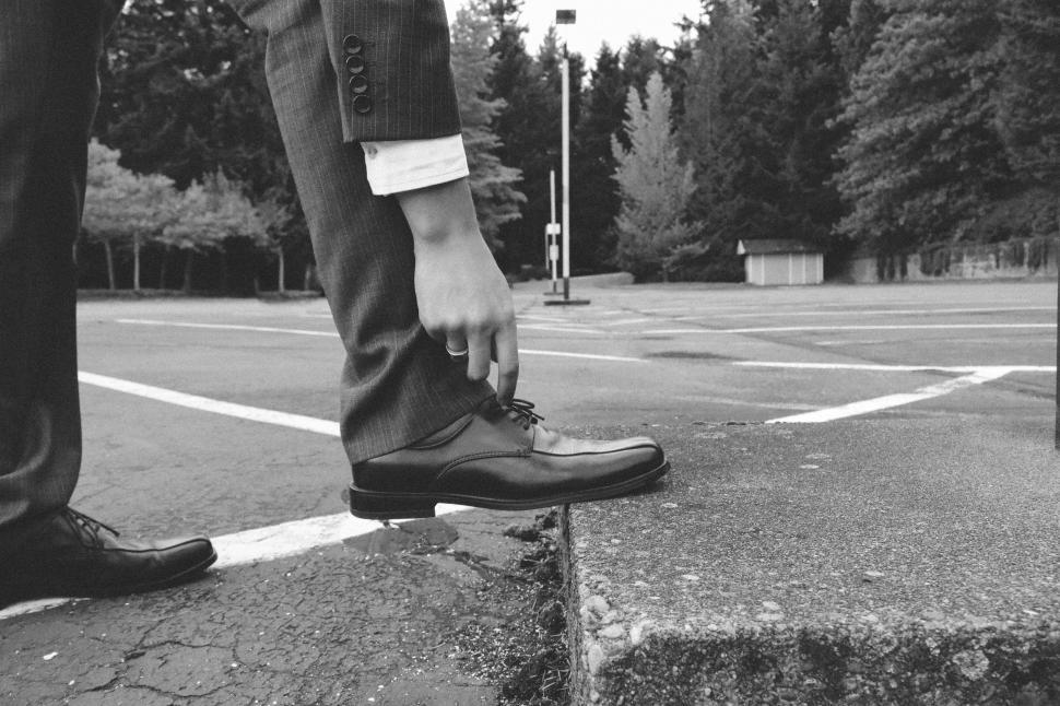 Free Image of Unrecognizable Man in suit tying shoe laces 