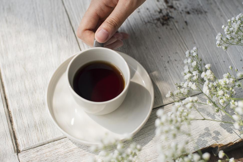 Free Image of Overhead view of a hand holding a cup of coffee 