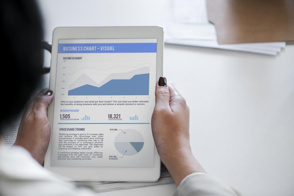 Free Image of Close up of hands holding a tablet PC displaying business data 