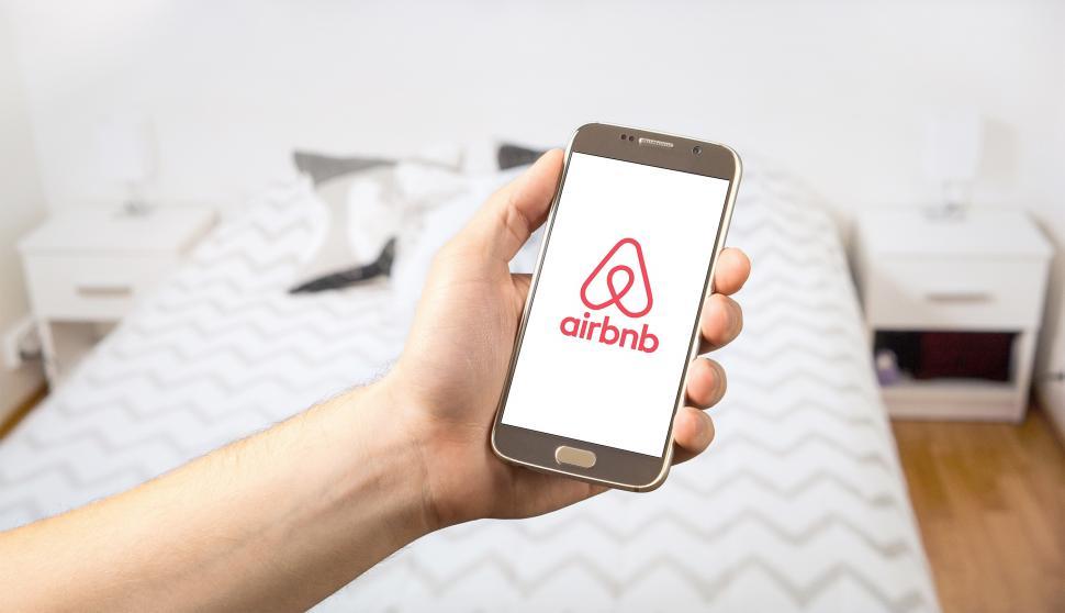 Free Image of Close up of a hand posing with a smartphone in a hotel room 