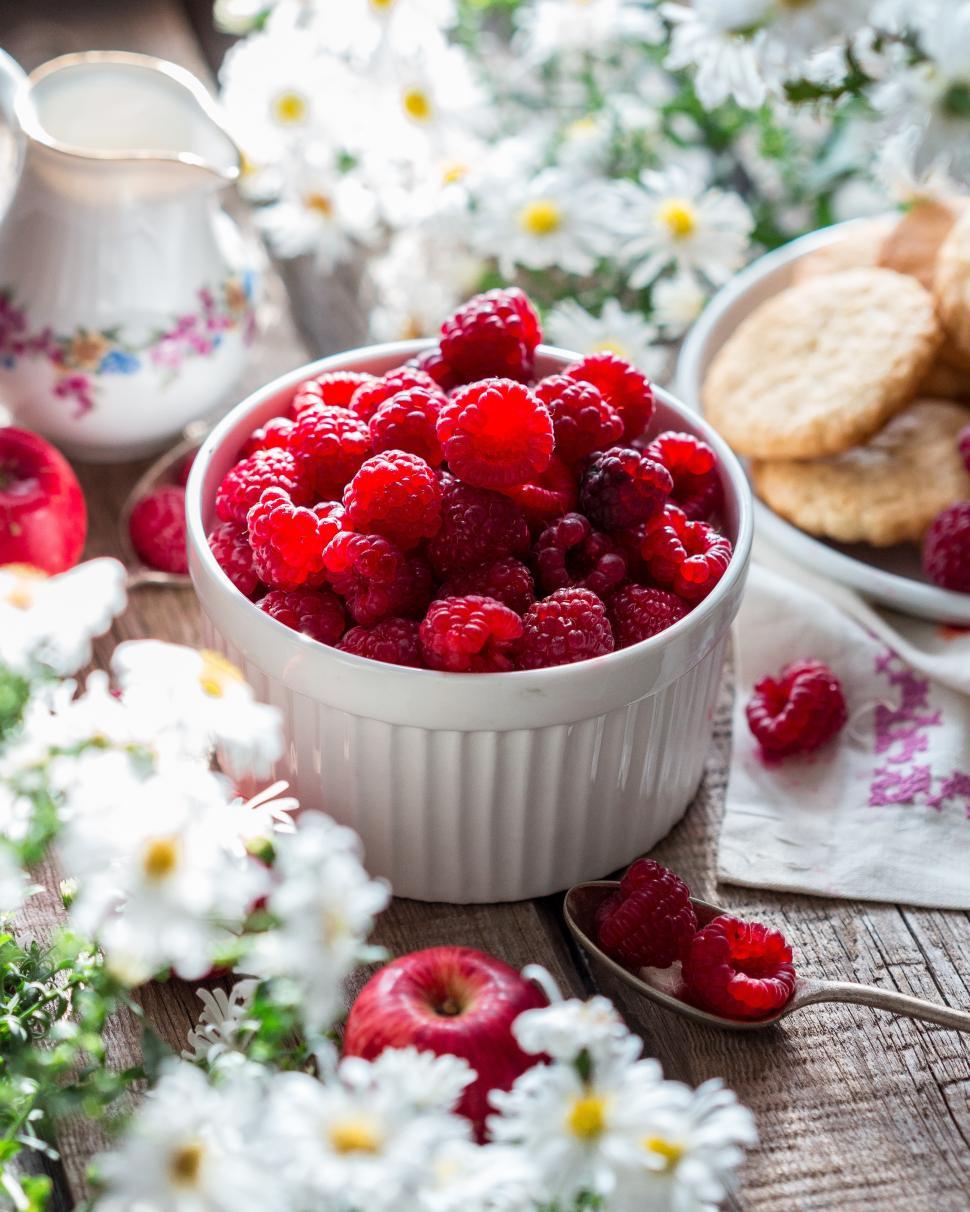 Free Image of Table with flowers and a bowl of raspberries 