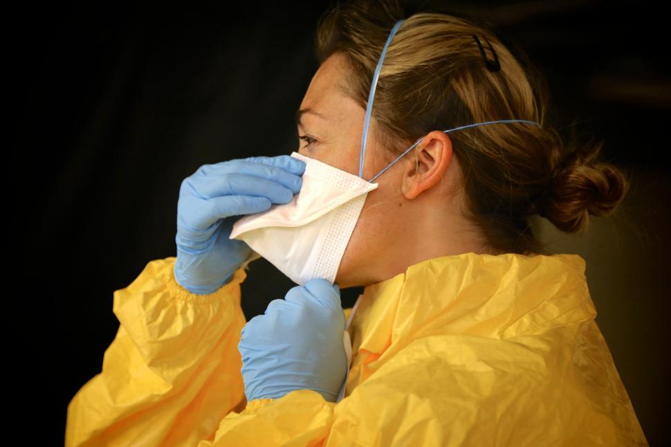 Free Stock Photo of Woman in Mask, Gloves, and Gown PPE Download