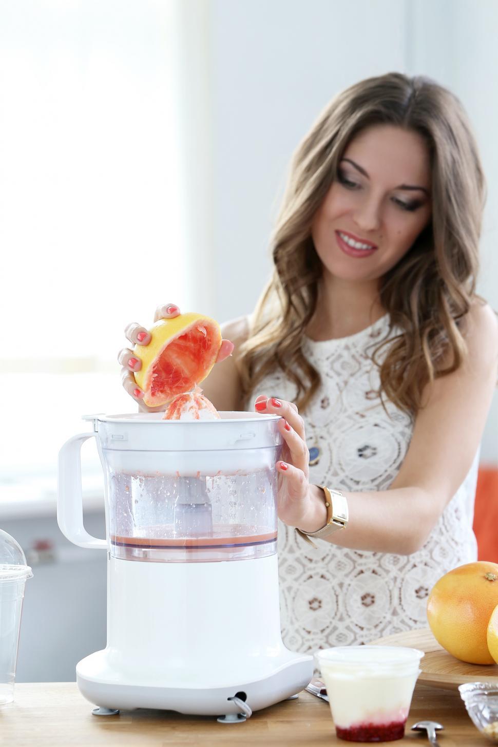 Free Image of Beautiful woman making orange juice 