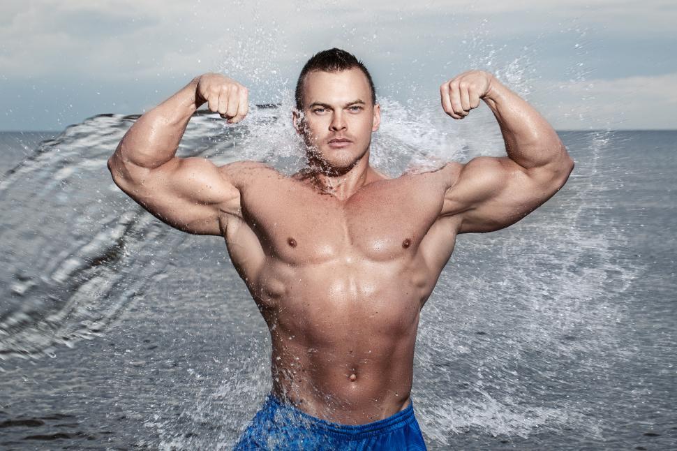 Bodybuilder in the ocean splash