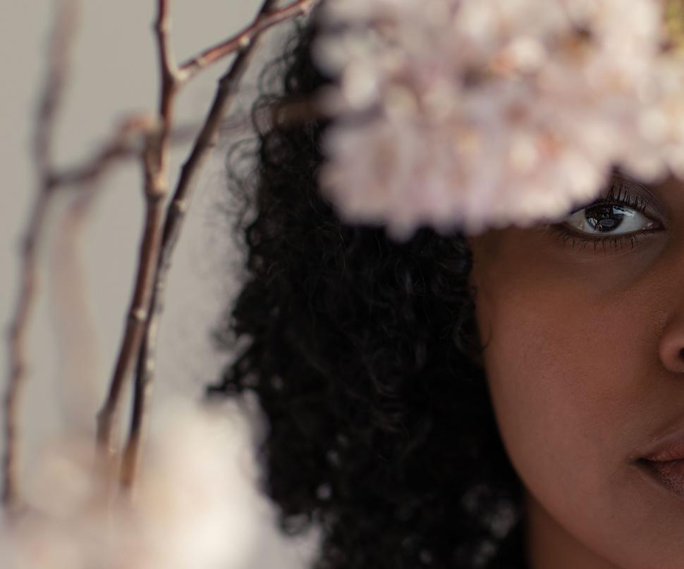 Free Image of Close up of young woman face with flowers and stem - eye contact 