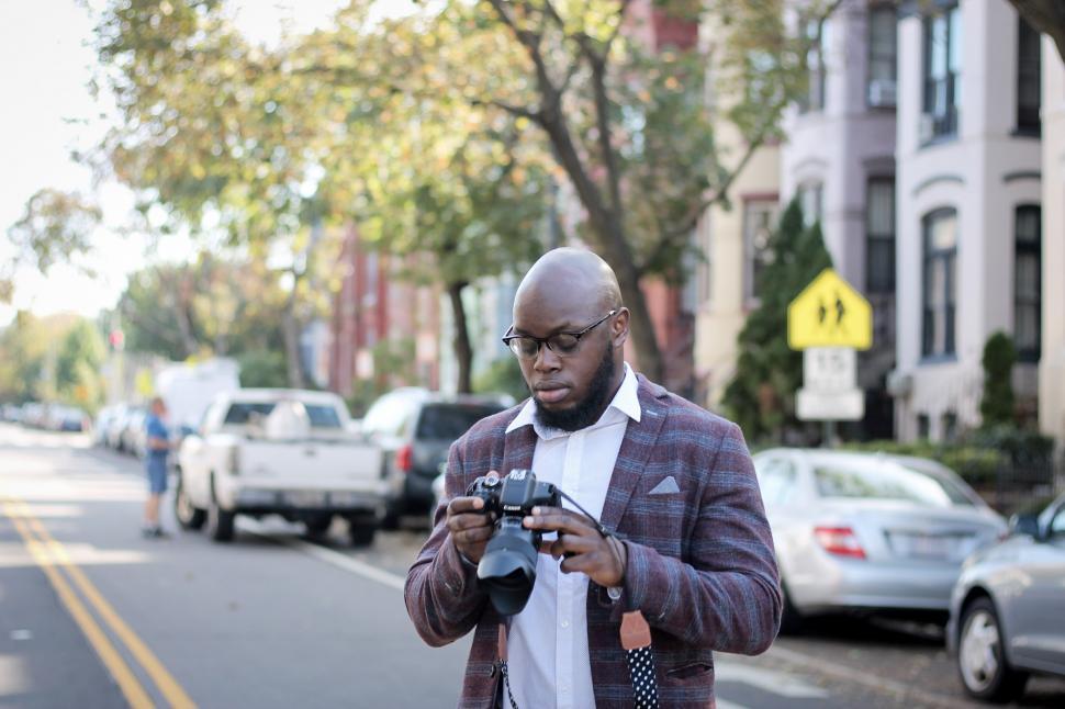 Free Image of Young photographer in spectacles with professional canon camera 